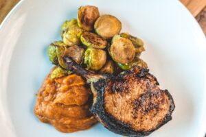 charred pork chop, brussel sprouts, and mashed sweet potatoes